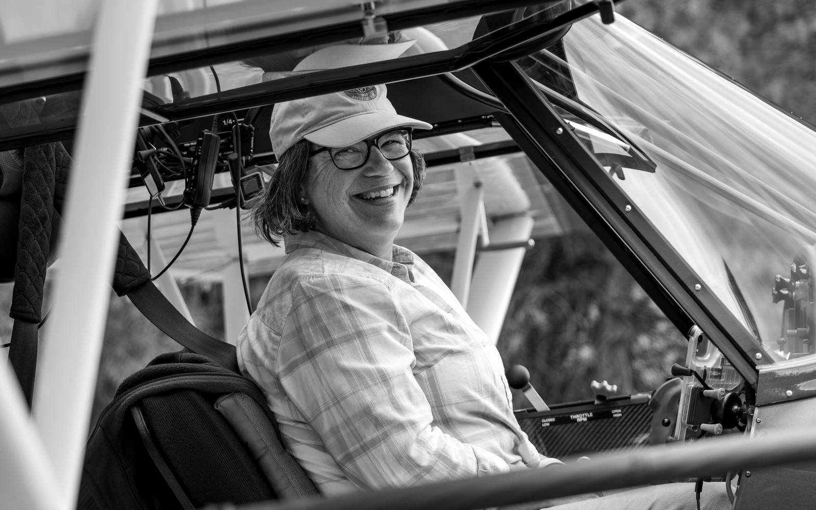 A guest smiling from the cockpit, in black and white